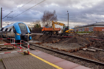 Zdjęcie: przez plac budowy jedzie pociąg.