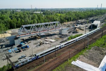 Nowe wiadukty kolejowe powstające przy stacji Katowice Zawodzie, widok lotniczy na obiekty i pociąg